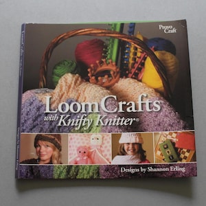 May include: A softcover instructional book titled Loom Crafts with Knifty Knitter by Shannon Erling. The cover features a basket filled with colorful yarn and knitting looms, along with four smaller photographs showing finished projects.