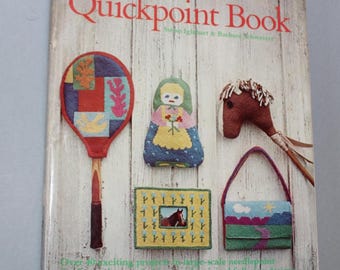 May include: The Quickpoint Book by Susan Iglehart & Barbara Schweizer. The cover features needlepoint projects: a tennis racket, doll, horse head, purse, and framed horse image. The book is on a white wooden background.