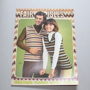 May include: A vintage knitting pattern book cover showing a man and woman in Fair Isle vests. The cover has a green background with the words "Fair Isles" in a brown and white font. The book is a vintage item.