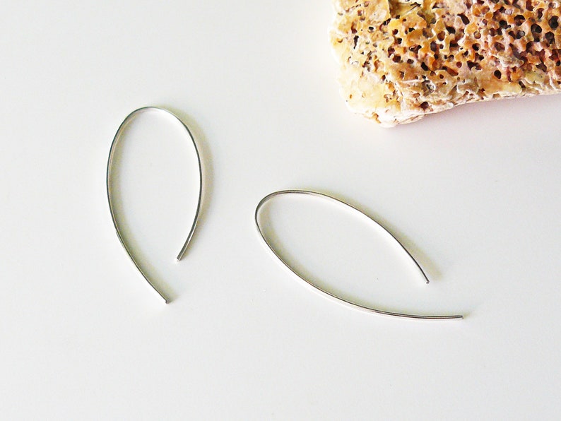 May include: A pair of silver hoop earrings with a simple, curved design.