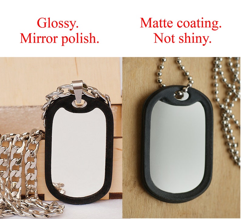 May include: Two dog tags on silver chains. The tag on the left has a mirror polish finish. The tag on the right has a matte coating. Both tags are black with a silver rim.