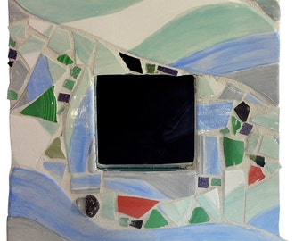 Op de afbeelding: Een mozaïekspiegellijst met een kleurenschema van blauw, groen, wit en grijs. De lijst is gemaakt van kleine stukjes tegel en glas.