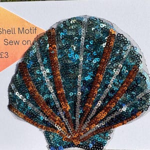 May include: A blue and brown sequined seashell applique with the text "Shell Motif Sew on £3".