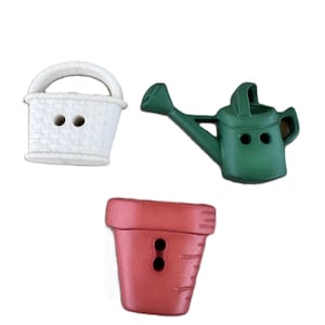 May include: A set of three decorative buttons shaped like garden items: a white basket with a woven texture, a green watering can with a long spout, and a red terracotta-style flower pot. Each button features two holes for attachment.