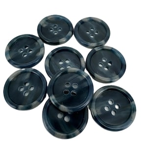 May include: Nine dark blue and grey marbled buttons, each with four holes. The round buttons have a glossy finish. Ideal for sewing projects or adding detail to garments.