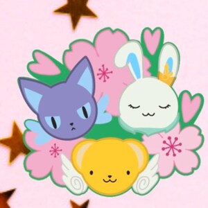 May include: A cartoon illustration featuring three characters: a purple cat, a white bunny with a crown, and a yellow bear, surrounded by pink flowers and green leaves. The background is light pink with gold star accents.