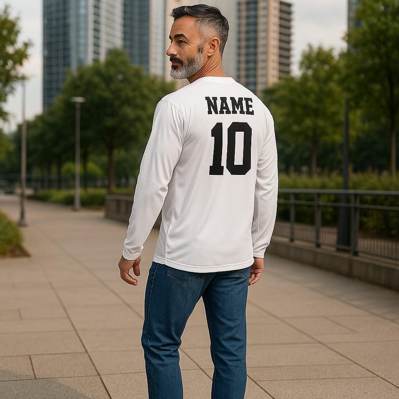 K&ouml;nnte beinhalten: Ein wei&szlig;es Langarmshirt mit dem Aufdruck "NAME 10" auf der R&uuml;ckseite in Schwarz.