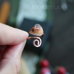 K&ouml;nnte beinhalten: Ein Ring aus Kupferdraht mit einer kleinen, braunen und wei&szlig;en Mausfigur. Die Maus hat ein wei&szlig;es Ohr und eine rosa Nase.