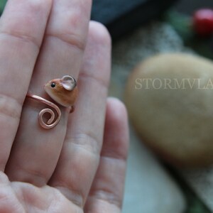 K&ouml;nnte beinhalten: Ein Ring aus Kupferdraht mit einer kleinen, braunen, geformten Mausfigur. Die Maus hat einen wei&szlig;en Bauch und eine rosa Nase.