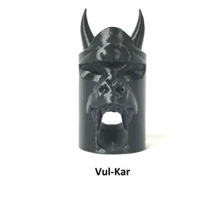 May include: Black plastic 3D printed object shaped like a demon's head with horns and fangs. The object has a hole in the mouth. The text "Vul-Kar" is printed below the object.