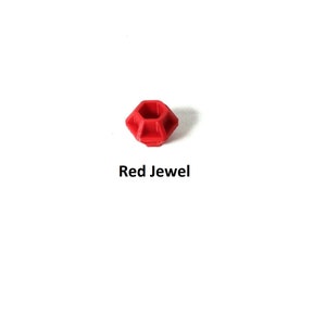 May include: A red jewel shaped like a dodecahedron.