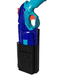May include: A blue and orange toy gun with a black holster. The holster has a pattern of hash marks on the front.