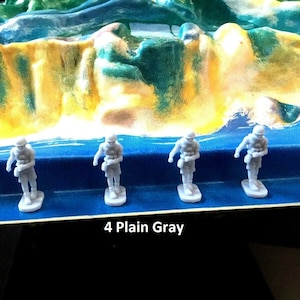 May include: Four gray plastic toy soldiers standing on a blue surface. The text "4 Plain Gray" is printed below the soldiers.