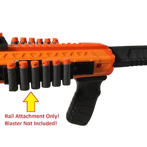 May include: Orange and black Nerf blaster attachment with a rail system that holds 10 darts.  The text "Rail Attachment Only! Blaster Not Included!" is printed below the attachment.