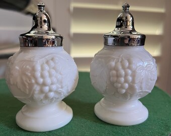 A pair of milk glass salt and pepper shakers. With grape motif