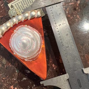 Peut inclure: Une d&eacute;coration de No&euml;l en verre en forme de part de tarte &agrave; la citrouille avec un motif en spirale blanc et une cro&ucirc;te dor&eacute;e. L'ornement mesure environ 7,5 cm de long et poss&egrave;de un cintre dor&eacute;.