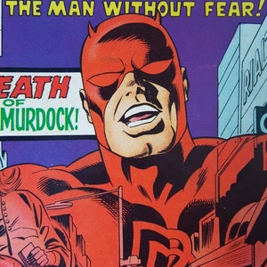 Op de afbeelding: Stripboekcover met Daredevil, een rood gekostumeerde superheld met hoorns, tegen een paarse achtergrond. Tekst bevat "Here Comes... Daredevil" en "The Man Without Fear!" met een stadsgezicht illustratie.