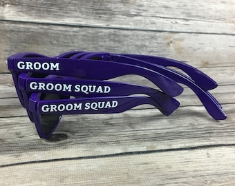 May include: Purple sunglasses with the text "Groom" and "Groom Squad" printed on the frames.