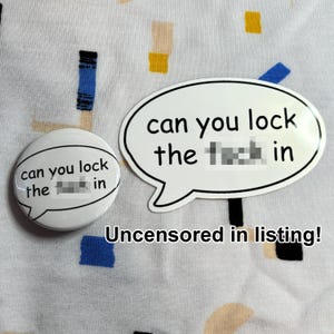 May include: Two white stickers and a button with the text "can you lock the f*** in". One sticker is speech bubble-shaped, the other is round. The background is a patterned fabric.