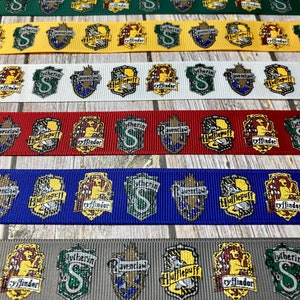 Op de afbeelding: Lint met verschillende huisschilden uit een fantasieserie. De linten zijn groen, geel, wit, rood, blauw en grijs. Elk lint toont de schilden van Zwadderich, Ravenklauw, Huffelpuf en Griffoendor.