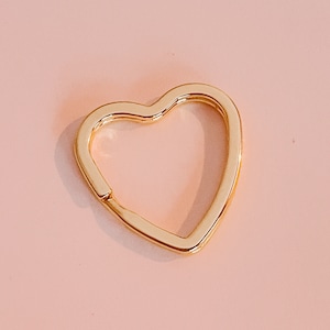 May include: A gold heart-shaped key chain ring.