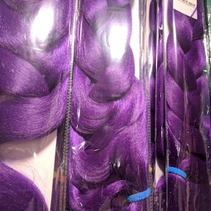 May include: Purple braiding hair extensions in a pre-braided style. The hair is packaged in plastic and is ready to be installed.