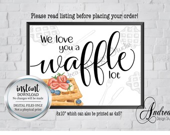 Puede incluir: Un cartel digital imprimible de 20,3 x 25,4 cm con el texto "We love you a waffle lot" en fuente cursiva negra. El cartel presenta una ilustración de acuarela de un waffle con fresas y arándanos en la parte superior. El cartel está enmarcado en un marco negro y tiene un fondo blanco.