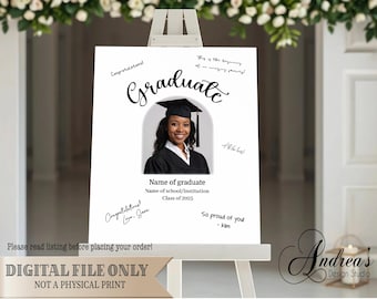 May include: A white sign with a black graduation cap and the word "Graduate" written in cursive. The sign has a space for a photo and a place for guests to sign their names. The text "Congratulations!" and "So proud of you" are written on the sign. The sign is on a wooden easel.