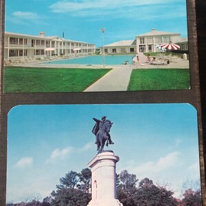 May include: Two vintage postcards. The top postcard shows a white building with a swimming pool in front of it. The bottom postcard shows a statue of a man on horseback.