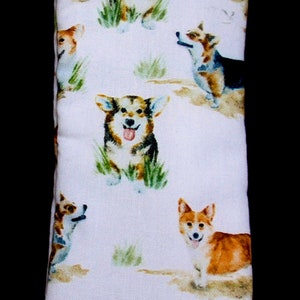 May include: White fabric pouch with a brown top seam. The pouch is decorated with a repeating pattern of watercolor-style images of corgis in various poses.