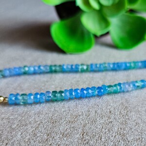 Peut inclure: Un collier d&eacute;licat compos&eacute; de perles de pierres pr&eacute;cieuses bleues et vertes, entrecoup&eacute;es de perles blanches et d'accents dor&eacute;s.