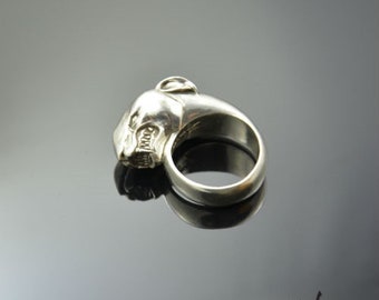 May include: A silver ring with a detailed panther head design. The ring is made of metal and has a smooth, polished finish.
