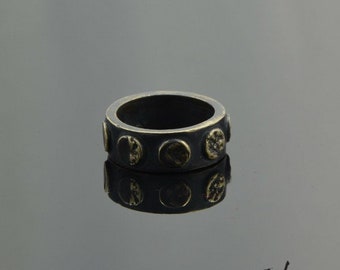 May include: A black and gold ring with a textured design. The ring has a band with six round, raised, gold-toned accents.