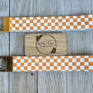Llavero de pulsera de cuero con diseño de cuadros en color naranja y blanco de TN