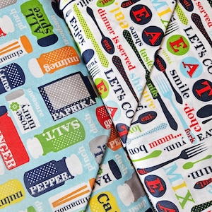 May include: Close-up of three fabric swatches with kitchen-themed patterns. One features spice shakers with labels like "Salt" and "Pepper" on a light blue background. Another has utensils and phrases like "Eat" and "Enjoy" on white. The third has similar text and utensils.