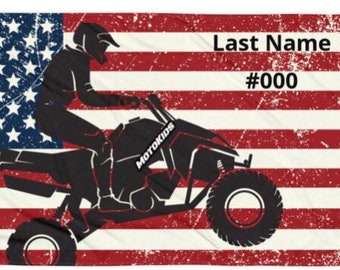 May include: A black and white silhouette of a person riding an ATV in front of an American flag with a distressed look. The text "Last Name #000" is on the flag.