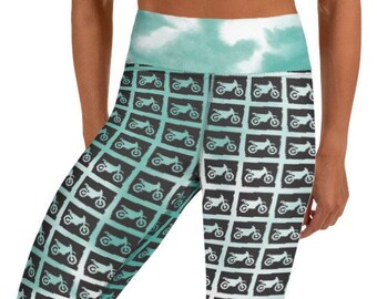 May include: Black yoga leggings with a teal and white ombre pattern featuring a repeated silhouette of a dirt bike.