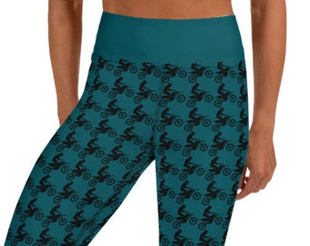 May include: Teal blue yoga leggings with a black and white repeating pattern of a person riding a dirt bike.