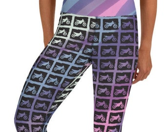 May include: Black and white patterned cropped leggings with a repeating design of motorcycles. The leggings have a gradient of pink, purple, and blue colors.