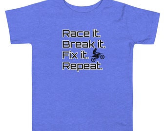 May include: A blue toddler t-shirt with the text "Race it. Break it. Fix it. Repeat." and a silhouette of a person riding a dirt bike.