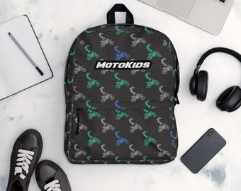 May include: Black backpack with a repeating pattern of green, blue, and gray motocross riders. The backpack has a white zipper and a white logo that says "MOTOKIDS".