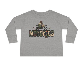 May include: A long-sleeved, heather gray shirt featuring a motocross-themed graphic. The design includes a rider on a motorcycle above the text "MOTOKIDS" in a camouflage pattern. The shirt is made of a soft material.