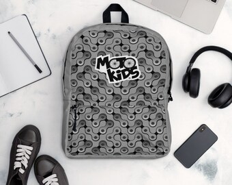 May include: Gray backpack with a black and white chain pattern and a black logo that says "Moto Kids".