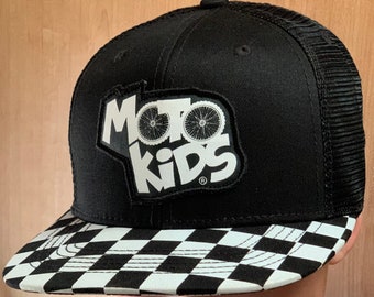 May include: Black and white checkered trucker hat with a black patch that says "Moto Kids" with a white bicycle wheel graphic.