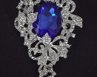 Grande broche de haute qualité en métal argenté et strass transparents avec grand cristal bleu royal