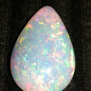Untreated Ethiopian Opal 31.14ct natural Earth mined crystal gemstone red, blue and green play of colour transparent crystally background