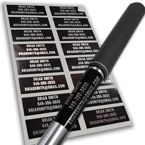 May include: A sheet of black and white rectangular labels with the text "BRIAN SMITH", a phone number, and an email address. A black pen with a textured grip is in the foreground, partially obscuring the labels.