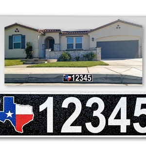 May include: A black and white house number sign with a Texas state outline in red, white, and blue. The number 12345 is printed in white on a black background. The sign is made of metal and has a textured surface.
