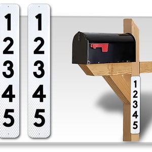 May include: Two white reflective address signs with black numbers 1 through 5. A black mailbox is mounted on a wooden post with a white reflective address sign with black numbers 1 through 5.
