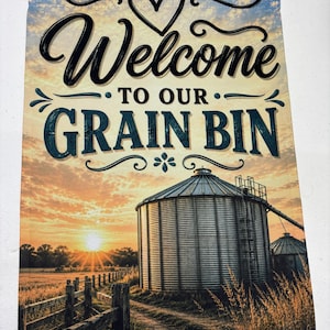 May include: A rectangular garden flag featuring a sunset landscape with a metal grain bin, a wooden fence, and a dirt path. The text "Welcome TO OUR GRAIN BIN" is printed in black and blue lettering at the top, accompanied by a heart graphic.